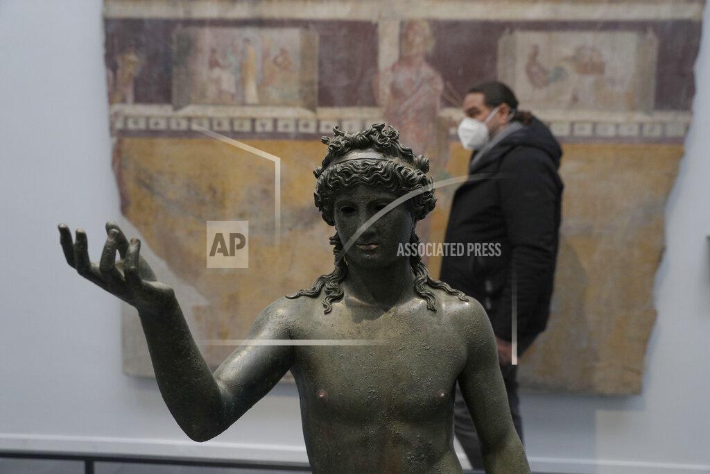 Gregorio Borgia A man walks past the statue of Ephebos inside the museum Antiquarium in Pompeii, southern Italy, Monday, Jan. 25, 2021.Decades after suffering bombing and earthquake damage, Pompeii's museum is back in business, showing off exquisite finds from excavations of the ancient Roman city. Officials of the archaeological park of the ruins of the city destroyed in 79 A.D. by the eruption of Mount Vesuvius inaugurated the museum on Monday. (AP Photo/Gregorio Borgia)