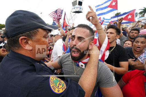 FILE - In this Wednesday, July 14, 2021, file photo, Miami Police Chief Art Acevedo, left, hugs a demonstrator, in Miami's Little Havana neighborhood, as people rallied in support of antigovernment demonstrations in Cuba. City of Miami commissioners held a special meeting in which they attacked Acevedo less than six months into his post, and voted to further investigate him and his appointment. (AP Photo/Wilfredo Lee, File)