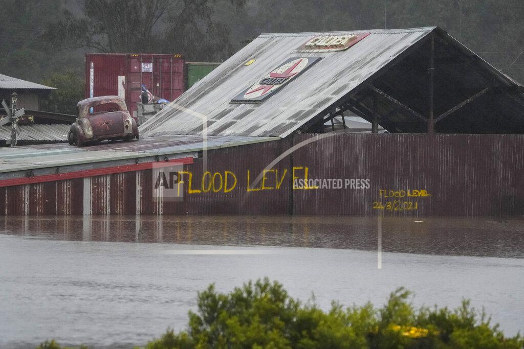 Mark Baker Flood waters surround an industrial property in Londonderry on the outskirts of Sydney, Australia, Monday, July 4, 2022. More than 30,000 residents of Sydney and its surrounds have been told to evacuate or prepare to abandon their homes on Monday as Australia's largest city braces for what could be its worst flooding in 18 months. (AP Photo/Mark Baker)