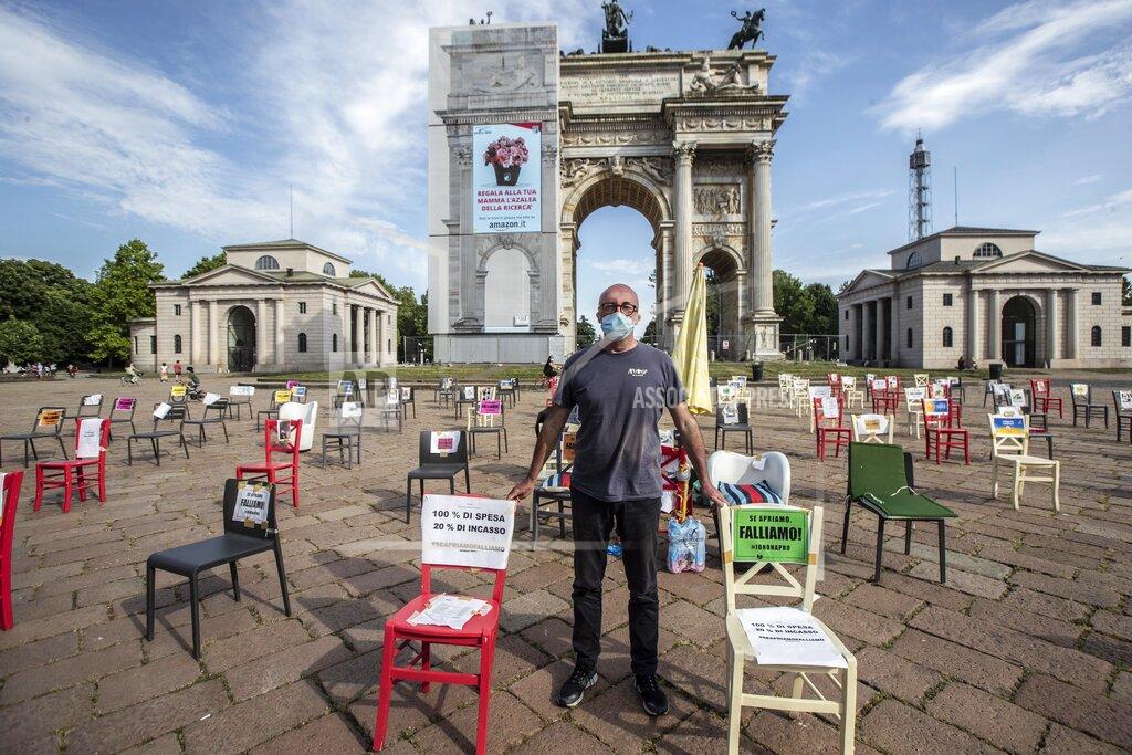 Luca Bruno Restaurant owner Paolo Polli stages a protest in Milan, Italy, Saturday May, 9, 2020. Hundreds of Milan bar and restaurant owners each placed an empty chair from their working places in front of the Arch of Peace in a protest demanding fiscal and other measures to help them survive the lockdown. Restaurants and bars can only open for sit-down clients from June 1. (AP Photo/Luca Bruno)