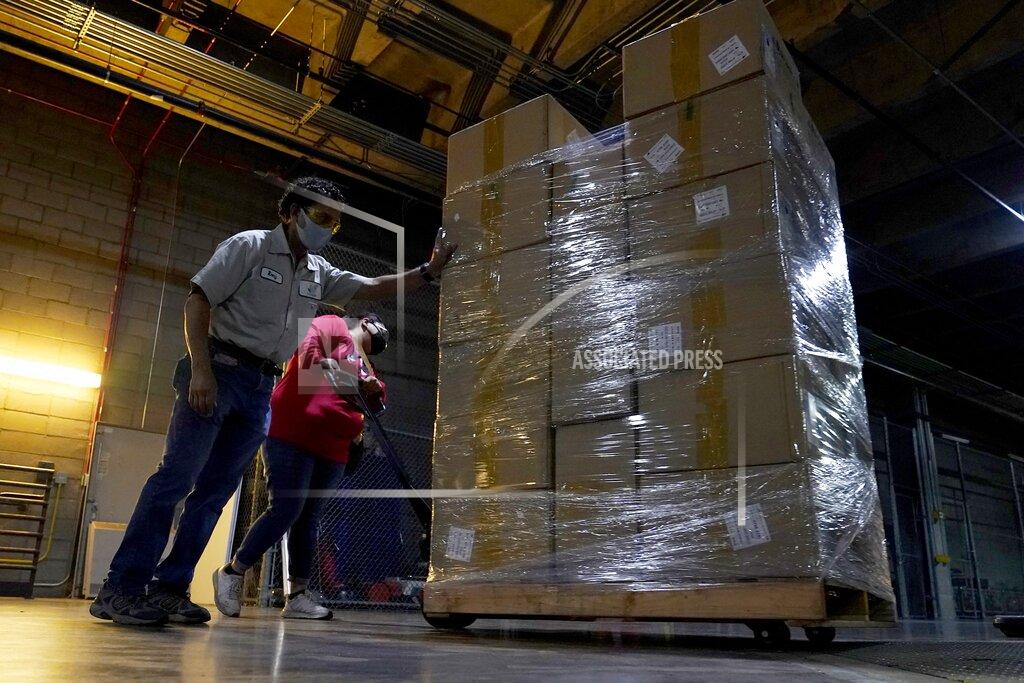 Ross D. Franklin Workers push one of dozens of pallets with more than one million pieces of PPE to help Phoenix schools reopen for the 2020-2021 school year onto a delivery truck as the City of Phoenix begins to ship the pallets out to schools Tuesday, Sept. 8, 2020, in Phoenix. (AP Photo/Ross D. Franklin)