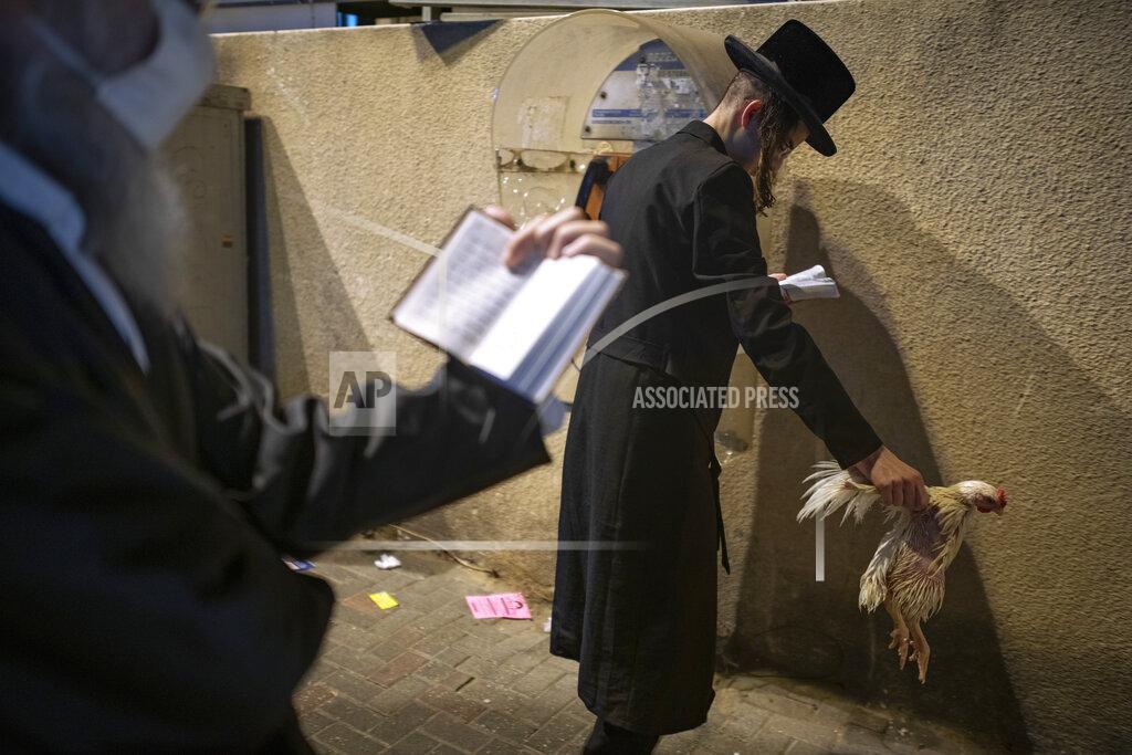 Oded Balilty An ultra-Orthodox Jewish man holds a chicken as part of the Kaparot ritual, in Bnei Brak, Israel, Sunday, Sept. 27, 2020. Observant Jews believe the ritual transfers one's sins from the past year into the chicken, and is performed before the Day of Atonement, Yom Kippur, the holiest day in the Jewish year which starts at sundown Sunday. The solemn Jewish holiday of Yom Kippur, which annually sees Israeli life grind to a halt, arrived on Sunday in a nation already under a sweeping coronavirus lockdown. (AP Photo/Oded Balilty)