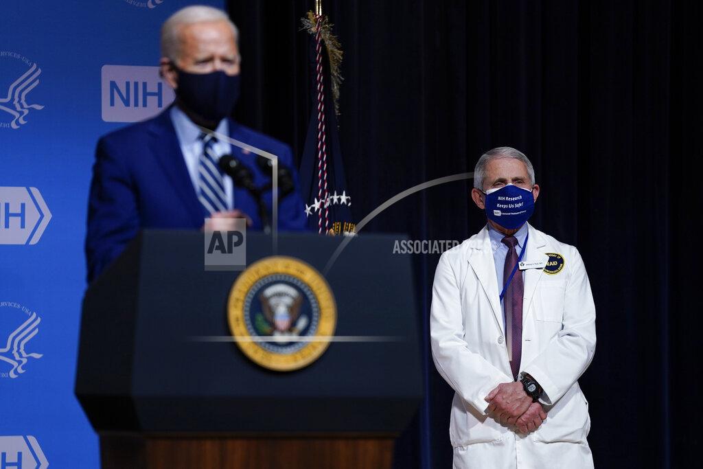 Evan Vucci President Joe Biden speaks during a visit to the Viral Pathogenesis Laboratory at the National Institutes of Health, Thursday, Feb. 11, 2021, in Bethesda, Md. Dr. Anthony Fauci, director of the National Institute of Allergy and Infectious Diseases, listens at right. (AP Photo/Evan Vucci)