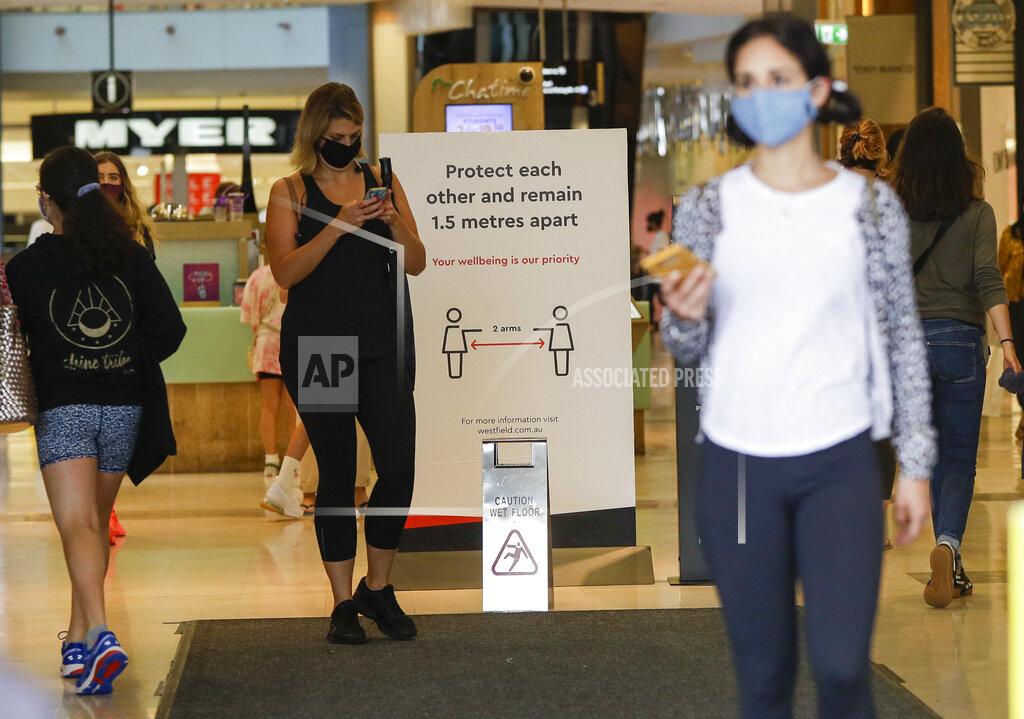 Mark Baker Shoppers wear masks as they walk around a shopping centre in Sydney, Australia, Sunday, Jan. 3, 2021. Masks have been made mandatory in shopping centers, on public transport, in entertainment venues such as a cinema, and fines will come into effect on Monday as the state government responds to the COVID-19 outbreak on Sydney's northern beaches, which is suspected to have also caused new cases in neighboring Victoria state. (AP Photo/Mark Baker)