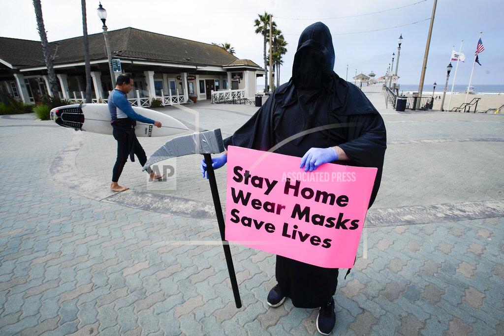 Chris Carlson FILE - In this May 8, 2020, file photo, Spencer Kelly, dressed as the grim reaper, demonstrates in favor of the stay-at-home order during the coronavirus pandemic at the pier in Huntington Beach, Calif. Now, in early May 2021, California has the lowest case rate in the country. (AP Photo/Chris Carlson, File)