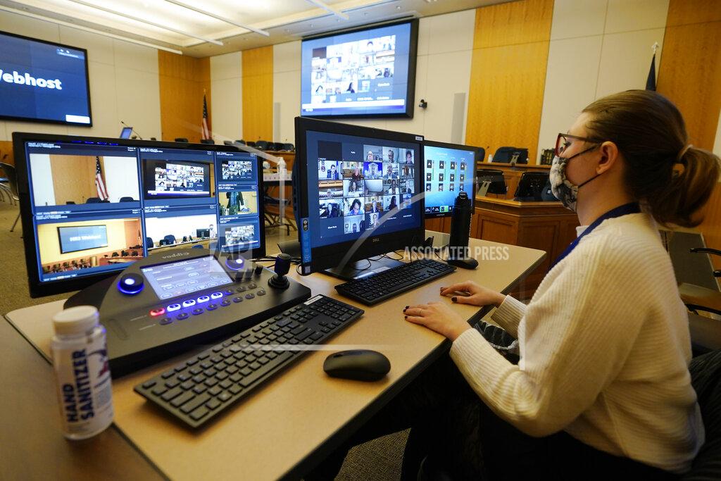 Steve Helber Carmen Senski, monitors a Zoom meeting of the Virginia House Appropriations Committee at the Capitol in Richmond, Va., Wednesday, Feb. 10, 2021. (AP Photo/Steve Helber)