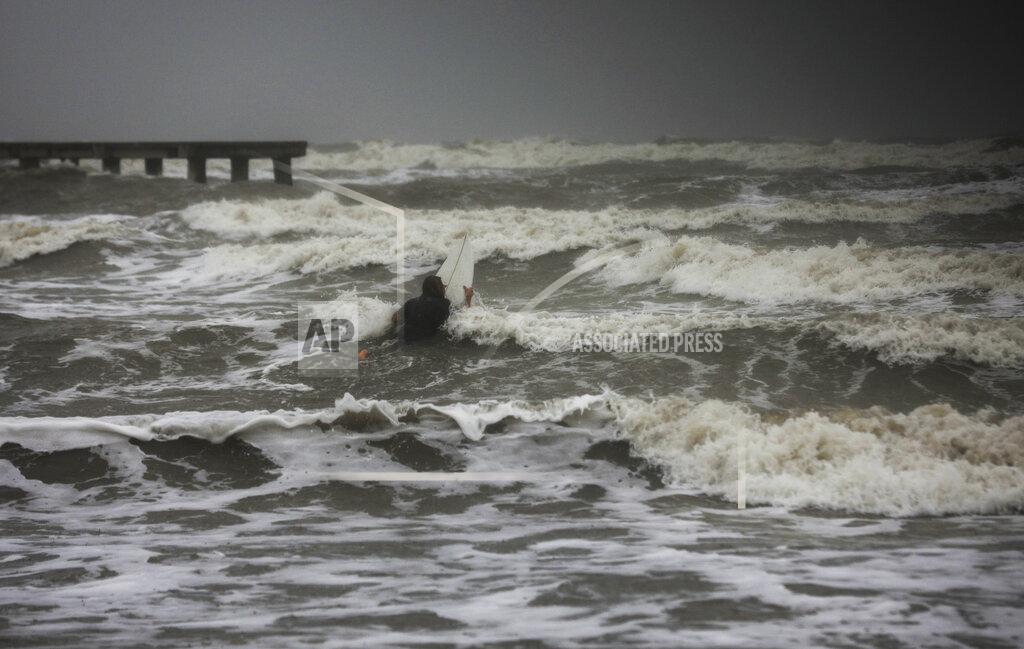 Jon Shapley A surfer tries to paddle through the surf as wind and rain from Tropical Storm Nicholas batters the area Monday, Sept. 13, 2021, along the seawall in Galveston, Texas. (Jon Shapley/Houston Chronicle via AP)