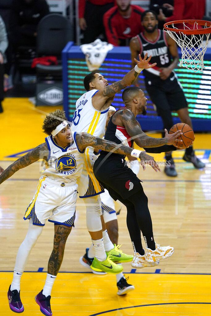 Tony Avelar Portland Trail Blazers guard Damian Lillard (0) drives to the basket against Golden State Warriors' Kelly Oubre Jr. (12) and Juan Toscano-Anderson, center, during the first half of an NBA basketball game in San Francisco, Friday, Jan. 1, 2021. (AP Photo/Tony Avelar)