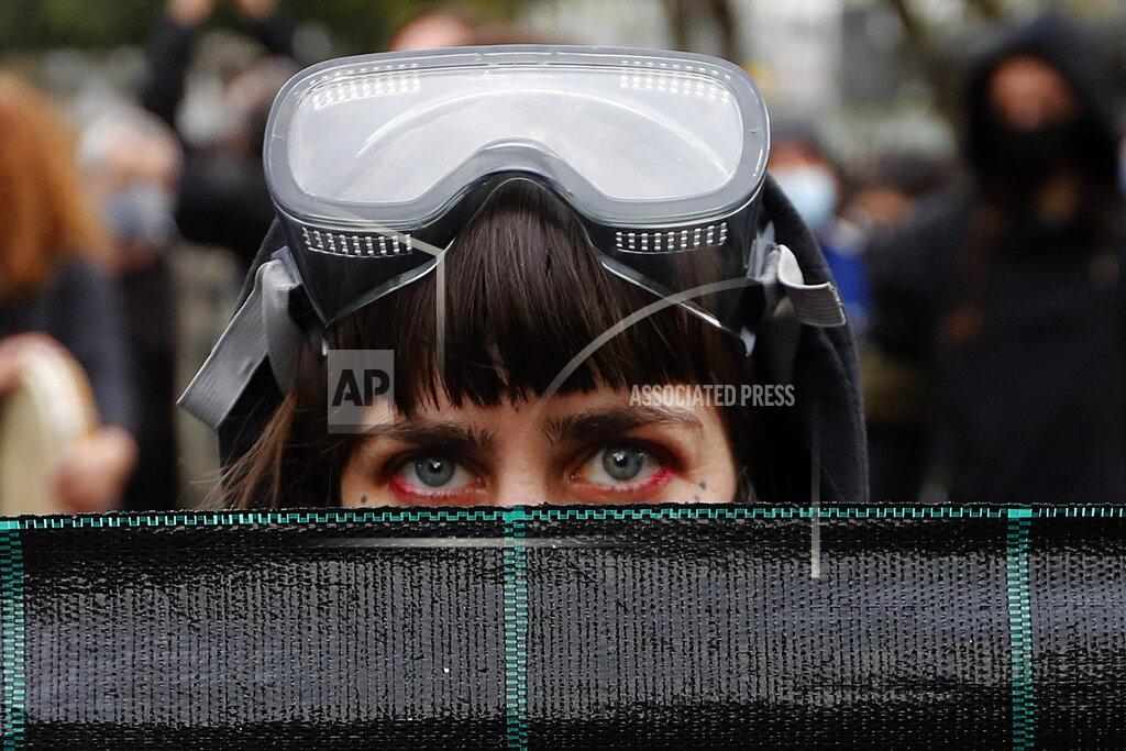Petros Karadjias A protestor with a diving mask on her head, holds a banner during a protest in the capital Nicosia, on Saturday, Feb. 20, 2021, against the corruption within the country's politicians, as well as fatigue over restrictions to curb COVID-19 infections. The demonstration that drew an estimated 3,000 people came a week after police were strongly criticized for resorting to disproportionate force by using a water canon, stun grenades and pepper spray to disperse a crowd of a few hundred left-wing protesters voicing their opposition to corrupt politicians. (AP Photo/Petros Karadjias)
