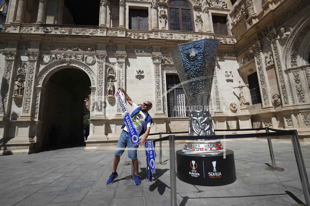 Angel Fernandez A supporter poses for a photo next to a replica trophy in downtown Seville, Spain, Tuesday, May 17, 2022. Eintracht Frankfurt will play Glasgow Rangers in the Europa League final Wednesday evening in Seville. (AP Photo/Angel Fernandez)