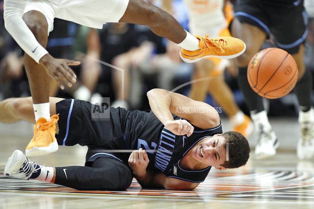 Jessica Hill Villanova's Collin Gillespie (2) falls to the ground while Tennessee's Victor Bailey Jr. (12) leaps over him while chasing a loose ball in the first half of an NCAA college basketball game, Saturday, Nov. 20, 2021, in Uncasville, Conn. (AP Photo/Jessica Hill)