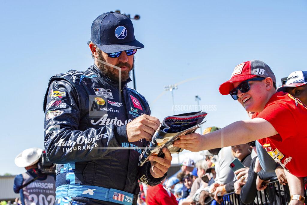 Mike Caudill Martin Truex Jr. signs an autograph at a NASCAR Cup Series auto race at Richmond Raceway on Sunday, April 3, 2022, in Richmond, Va. (AP Photo/Mike Caudill)