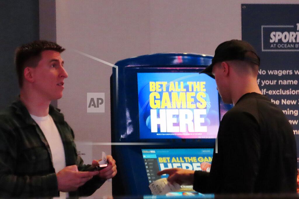 Wayne Parry People make bets at the sportsbook at the Ocean Casino Resort, on Thursday, Feb. 10, 2022, in Atlantic City, N.J. The American Gaming Association estimates more than 31 million Americans will bet on this year's Super Bowl NFL football game. (AP Photo/Wayne Parry)