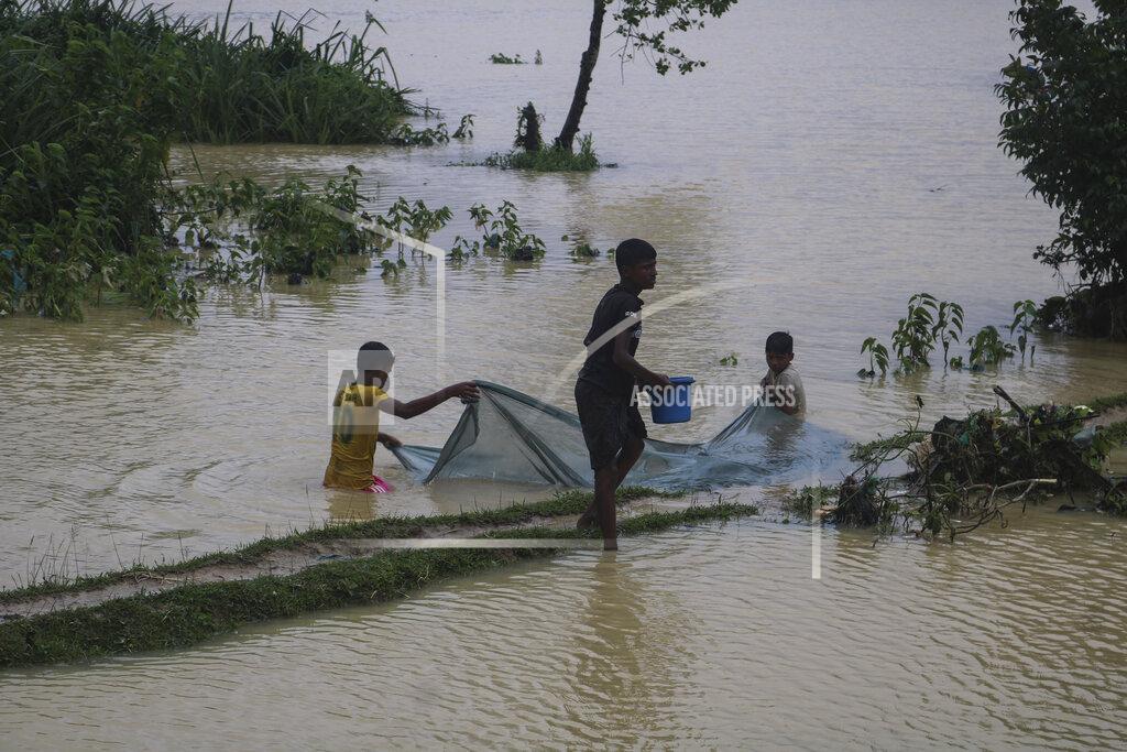 Shafiqur Rahman Rohingya refugees fish in flood waters following heavy rains at the Rohingya refugee camp in Kutupalong, Bangladesh, Wednesday, July 28, 2021. Days of heavy rains have brought thousands of shelters in various Rohingya refugee camps in Southern Bangladesh under water, rendering thousands of refugees homeless. (AP Photo/ Shafiqur Rahman)