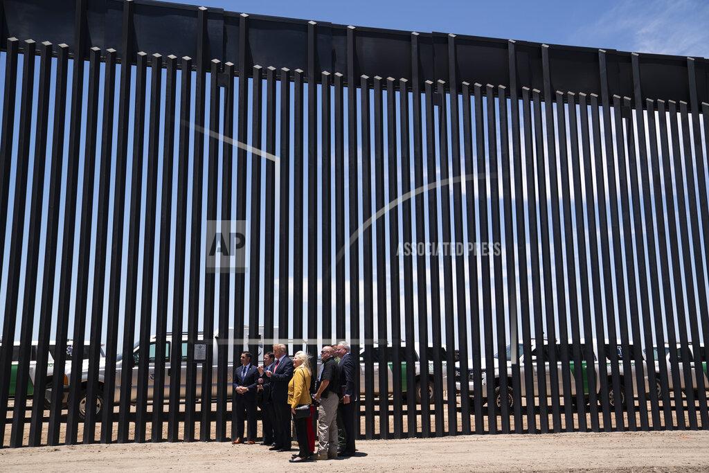 President Donald Trump poses for photos during a tour of a section of the border wall, Tuesday, June 23, 2020, in San Luis, Ariz. (AP Photo/Evan Vucci)