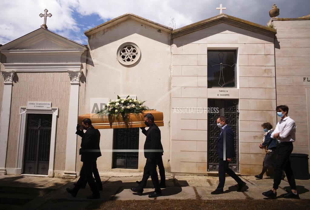Domenico Stinellis FILE - In this May 12, 2020 file photo, the casket containing the body of Annunziata Ginoble, the mother of Mayor of Roseto degli Abruzzi Sabatino Di Girolamo, third from right, with his sister, Marisa Di Felice, second from right, and his son, Francesco, right, is taken to her burial site inside the small cemetery of Montepagano, central Italy. Italy is poised to reclaim the dishonor of reporting the most coronavirus deaths in Europe, as the second surge ravages the country’s disproportionately old population and exposes how public health shortfalls and delayed restrictions compounded a lack of preparedness going into the pandemic. (AP Photo/Domenico Stinellis, file)