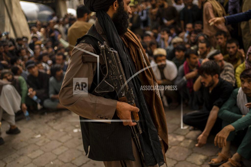 Bernat Armangue A Taliban fighter controls a crowd waiting to withdraw money from a bank branch in Kabul, Afghanistan, Sunday, Sept. 12, 2021. (AP Photo/Bernat Armangue)