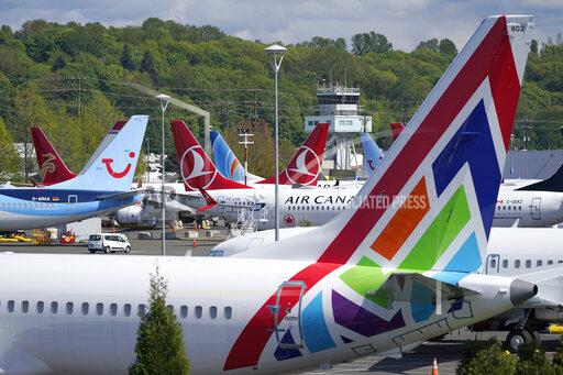 FILE — In this April 26, 2021, file photo Boeing 737 Max airplanes sit parked in a storage lot, near Boeing Field in Seattle. The Boeing Co. told employees, Tuesday, Oct. 12, 2021, that they must be vaccinated against COVID-19 or possibly be fired. The Seattle Times reports the deadline for workers at the aerospace giant is Dec. 8. (AP Photo/Ted S. Warren, File)