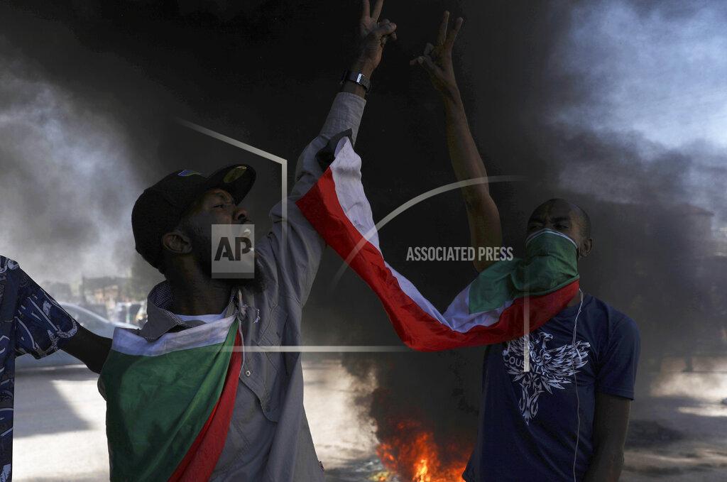 Marwan Ali A demonstrator gives the victory sign during a protest, in Khartoum, Sudan, Saturday, Dec. 19, 2020. Protests in Sudan’s capital and across the country are demanding a faster pace to democratic reforms, in demonstrations that are marking the two-year anniversary of the uprising that led to the military’s ouster of strongman Omar al-Bashir. (AP Photo/Marwan Ali)
