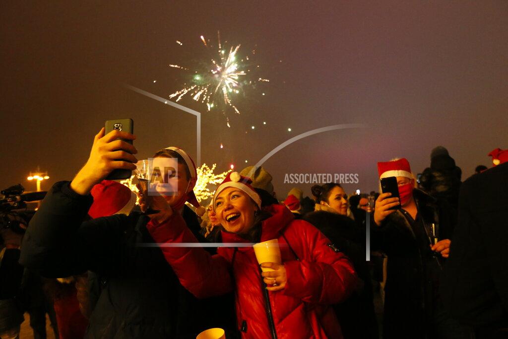 Alexander Zemlianichenko Jr Passengers of a party bus celebrate New Year after driving through Moscow, Russia, Friday, Jan. 1, 2021. While restaurants and other entertainment venues close its doors across the country at 23:00, Muscovites look for ways to bend the coronavirus restrictions. One of them is a party bus whose owners offer to spend the New Year night touring around the city and having drinks with other strangers. (AP Photo/Alexander Zemlianichenko Jr)