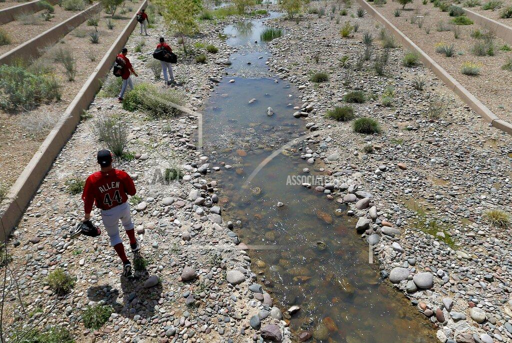 Matt York FILE - In this March 21, 2013, file photo, Arizona Diamondbacks minor league players walk along a stream between fields prior to a spring training baseball game against the Cleveland Indians, in Scottsdale, Ariz. With Major League Baseball successfully resisting legal efforts to raise minor league salaries, players are beginning to look elsewhere to make ends meet. (AP Photo/Matt York, File)