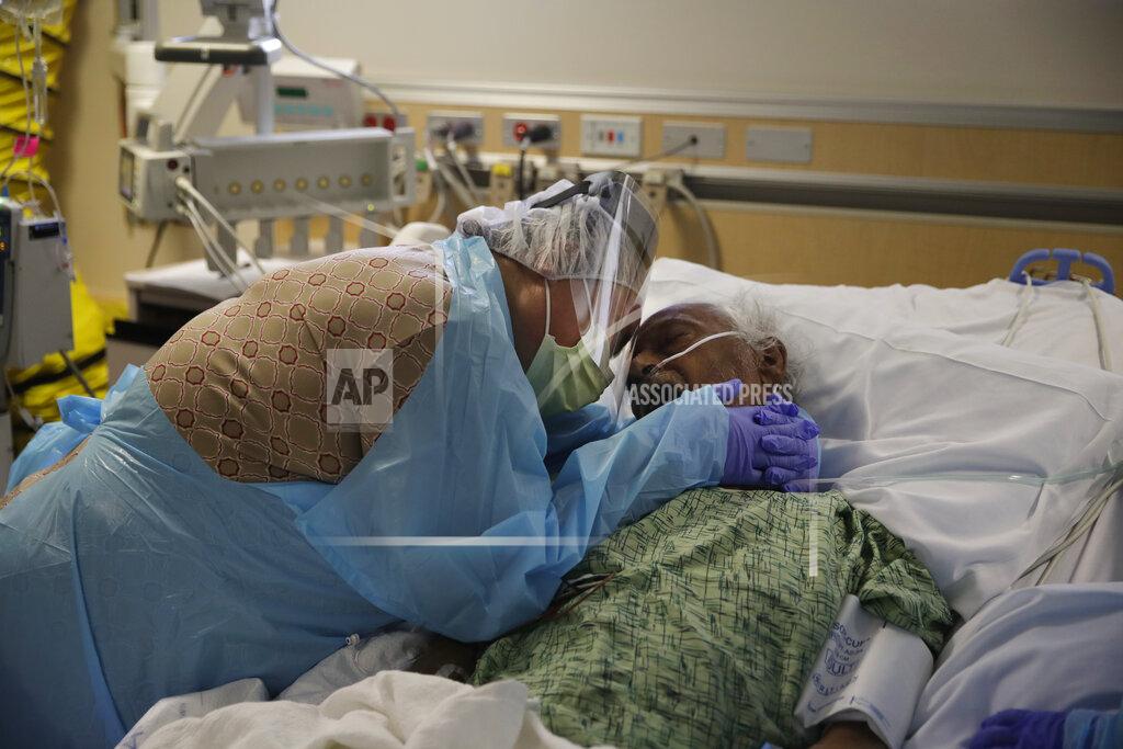 Jae C. Hong FILE - In this July 31, 2020, file photo, Romelia Navarro, 64, weeps while hugging her husband, Antonio, in his final moments in a COVID-19 unit at St. Jude Medical Center in Fullerton, Calif. The U.S. death toll from COVID-19 has almost topped 500,000 — a number so staggering that a top health researchers says it is hard to imagine an American who hasn't lost a relative or doesn't know someone who died. (AP Photo/Jae C. Hong, File)