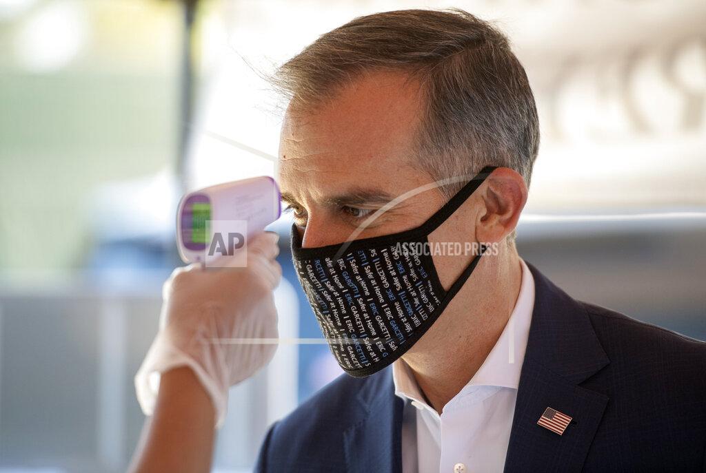 FILE - In this Tuesday, May 19, 2020, file photo, Los Angeles Mayor Eric Garcetti has his temperature taken during a screening amid the coronavirus pandemic before a news briefing at the Los Angeles Jewish Home in Reseda, Calif. Los Angeles Mayor Garcetti says a lot of pandemic deaths could have been prevented in California if the state had focused earlier on vaccinating people in the most disadvantaged neighborhoods. Garcetti also said Friday, March 19, 2021, the federal and state governments haven't given local officials like him enough freedom to inoculate who they feel are most at risk. (Hans Gutknecht/The Orange County Register via AP, File)