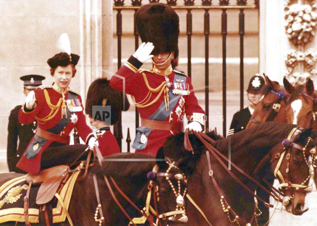 Horst Faas FILE - In this file photo dated June 14, 1975, Britain's Queen Elizabeth II and her husband Prince Philip take the salute on horseback outside the gates of Buckingham Palace in London, following the annual Trooping of the Colour ceremony. Prince Philip who died Friday April 9, 2021, aged 99, lived through a tumultuous century of war and upheavals, but he helped forge a period of stability for the British monarchy under his wife, Queen Elizabeth II. (AP Photo/Horst Faas, FILE)