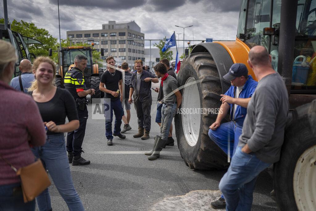 Peter Dejong Some 25 tractors parked outside a distribution center for supermarket chain Albert Heijn during a blockade in the town of Zaandam, just north of Amsterdam, Monday, July 4, 2022. Dutch farmers angry at government plans to slash emissions used tractors and trucks Monday to blockade supermarket distribution centers, the latest actions in a summer of discontent in the country's lucrative agricultural sector. (AP Photo/Peter Dejong)