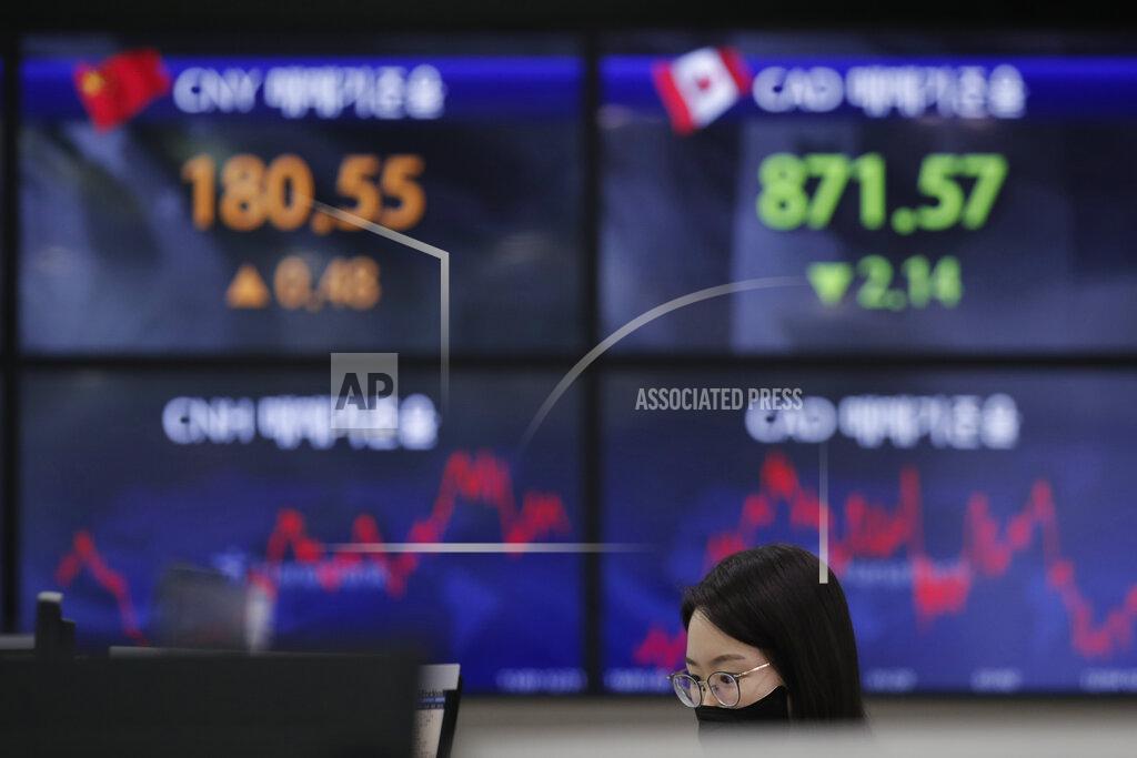 Lee Jin-Man An employee of a bank watches computer monitors near screens showing the foreign exchange rates at the foreign exchange dealing room in Seoul, South Korea, Thursday, Feb. 4, 2021. Asian shares mostly fell Thursday as caution set in over company earnings reports, recent choppy trading in technology stocks and prospects for more economic stimulus for a world battling a pandemic. (AP Photo/Lee Jin-man)