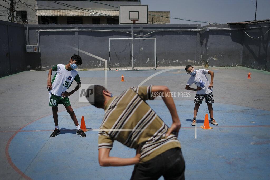 Matias Delacroix Children wearing protective face masks as a measure to curb the spread of the new coronavirus, stretch their muscles before they play a game of soccer, in the Lidice neighborhood of Caracas, Venezuela, Saturday, May 16, 2020. President Nicolas Maduro is relaxing quarantine measures over the weekend by allowing children and older adults out of their homes for a few hours each day. (AP Photo/Matias Delacroix)