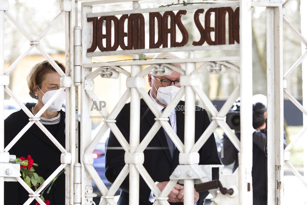 Markus Schreiber German President Frank-Walter Steinmeier, right, and his wife Elke Buendenbender, left, walk through the entrance gate of the Nazi concentration camp 'Buchenwald' with the inscription 'Jedem das Seine' (To Each His Own) as they arrive for commemorations marking the 76th anniversary of the liberation of the Nazi camp near Weimar, Germany, Sunday, April 11, 2021. On April 11, 1945 the US Army liberated the concentration camp Buchenwald. (AP Photo/Markus Schreiber)