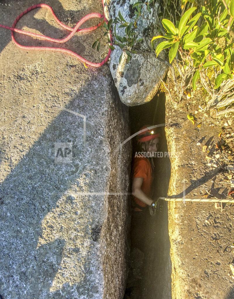 Uncredited This photo provided by New York State Parks on Wednesday, Oct. 13, 2021, shows parks official Jessica Van Ord entering a fissure to rescue a 12-year-old dog named Liza, found trapped after five days deep inside the narrow, rocky crevice at Minnewaska State Park Preserve in Kerhonkson, N.Y. A dog trapped for five days deep inside a narrow, rocky crevice at a state park north of New York City was rescued unharmed — though it was hungry and thirsty, parks officials said Wednesday.(New York State Parks via AP)