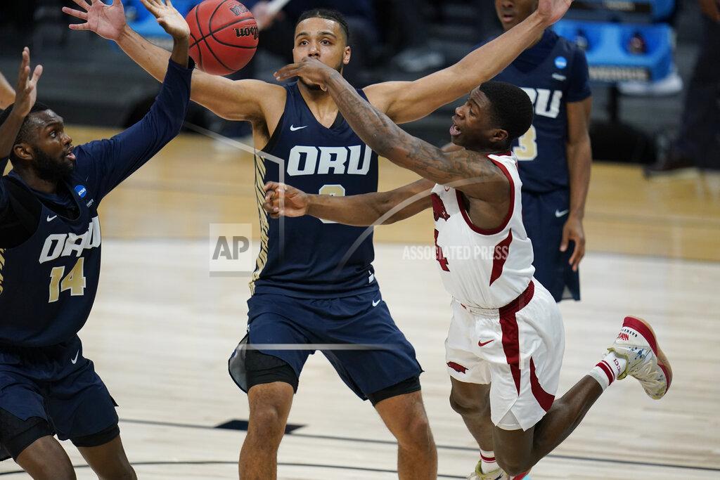 Jeff Roberson Arkansas guard Davonte Davis, right, passes over Oral Roberts forward DeShang Weaver (14) and forward Kevin Obanor during the first half of a Sweet 16 game in the NCAA men's college basketball tournament at Bankers Life Fieldhouse, Saturday, March 27, 2021, in Indianapolis. (AP Photo/Jeff Roberson)