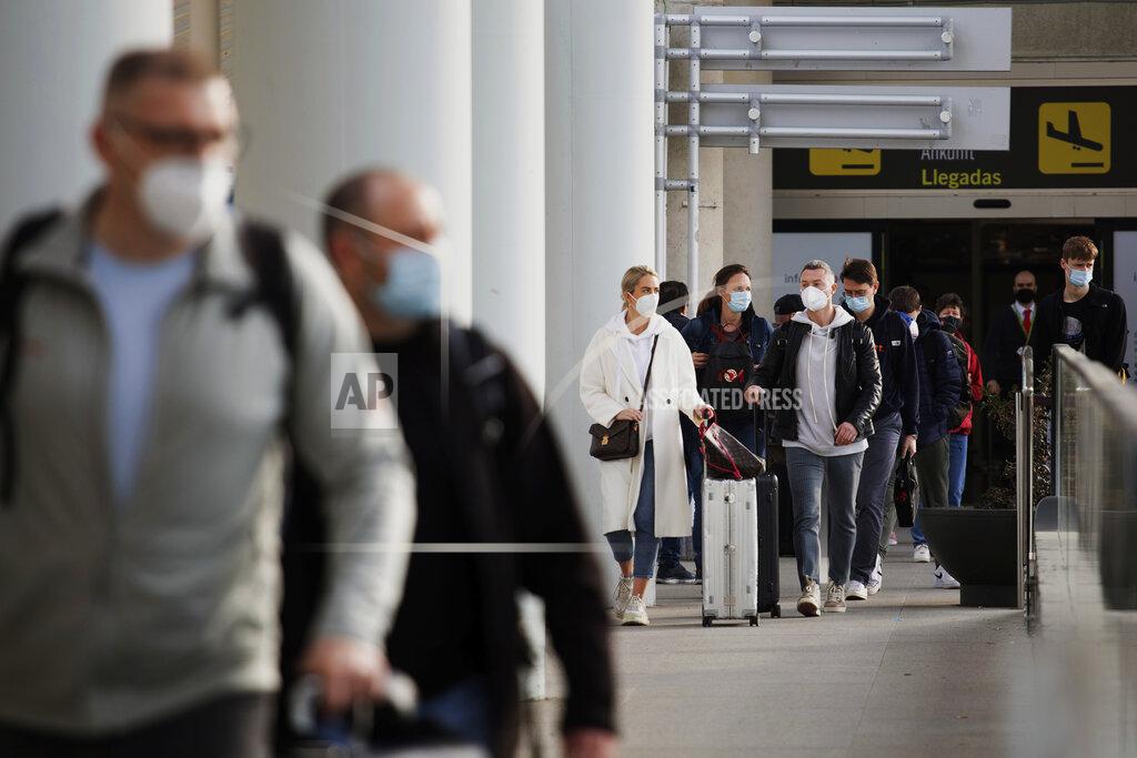 Francisco Ubilla Passengers wearing face masks arrive at Palma de Mallorca Airport on the Spanish Balearic Island of Mallorca, Spain, Saturday, March 27, 2021. Efforts in Spain to restart tourism activity is drawing a mixed picture due to a patchwork of national, regional and European rules on travel that is confusing both tourists and their hosts. (AP Photo/Francisco Ubilla)