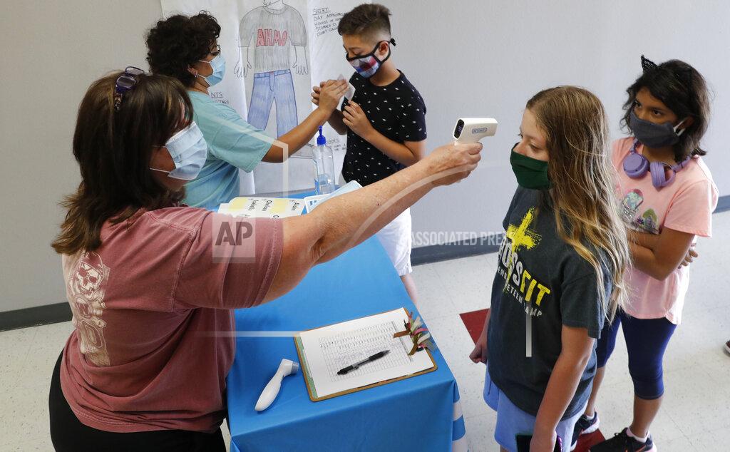 Lm Otero FILE - In this July 14, 2020, file photo, amid concerns of the spread of COVID-19, science teachers Ann Darby, left, and Rosa Herrera check-in students before a summer STEM camp at Wylie High School in Wylie, Texas. Schools and camps across the county are making plans to help kids catch up academically this summer after a year or more of remote learning for many of them. (AP Photo/LM Otero, File)