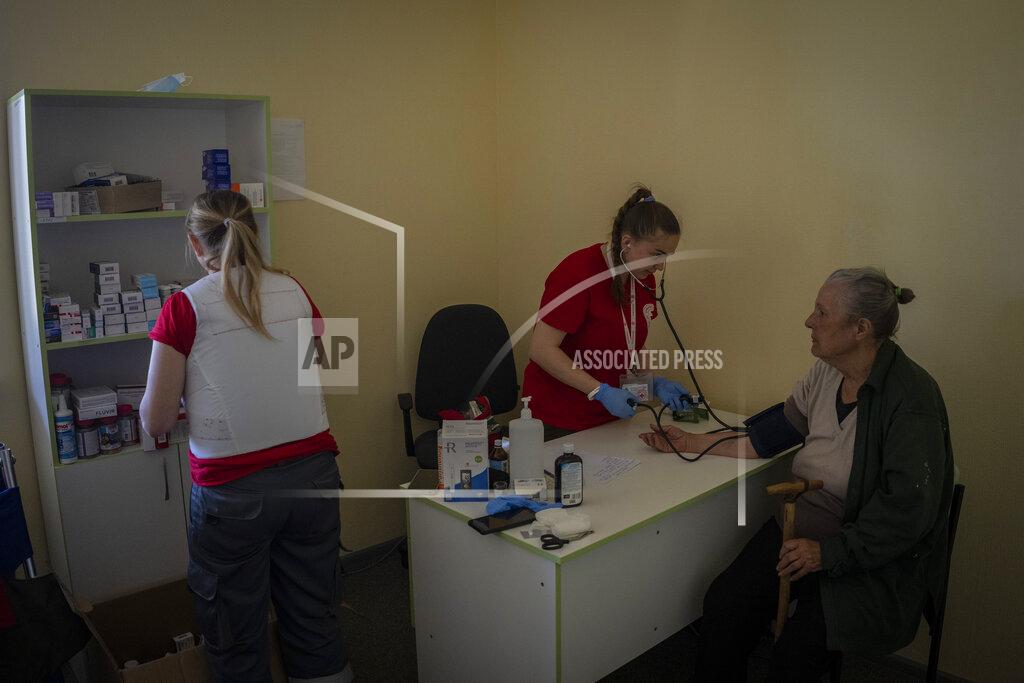 Bernat Armangue Members of the Kharkiv Red Cross carry out a medical check-up on a resident of the village of Staryi Saltiv, east Kharkiv, Ukraine, Friday, May 20, 2022. The village formerly occupied by Russian forces is back under Ukrainian control, albeit very close to the front line and under constant shelling. (AP Photo/Bernat Armangue)