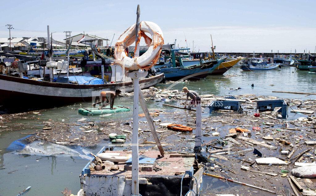 Armin Septiexan Indonesian men look for salvageable items amid debris and damaged boats following a storm at a port in Kupang, East Nusa Tenggara province, Indonesia Wednesday, April 7, 2021. Multiple disasters caused by severe weather in eastern Indonesia and neighboring East Timor have left a number of people dead or missing. (AP Photo/Armin Septiexan)