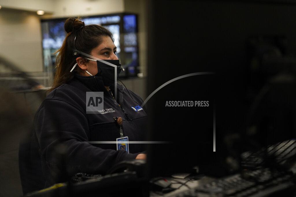 Jae C. Hong Dispatcher Ashley Cortez responds to a call in Care Ambulance Service's communication center in Santa Fe Springs, Calif., Saturday, Jan. 9, 2021. Dispatchers play chess with ambulances all day. When one gets stuck at a hospital for eight, 10 or 12 hours, the dispatchers must reposition the others to cover its area. When an EMT reports a positive COVID-19 test, the dispatchers must find a way to cover the ambulance's calls if the whole crew must quarantine. (AP Photo/Jae C. Hong)