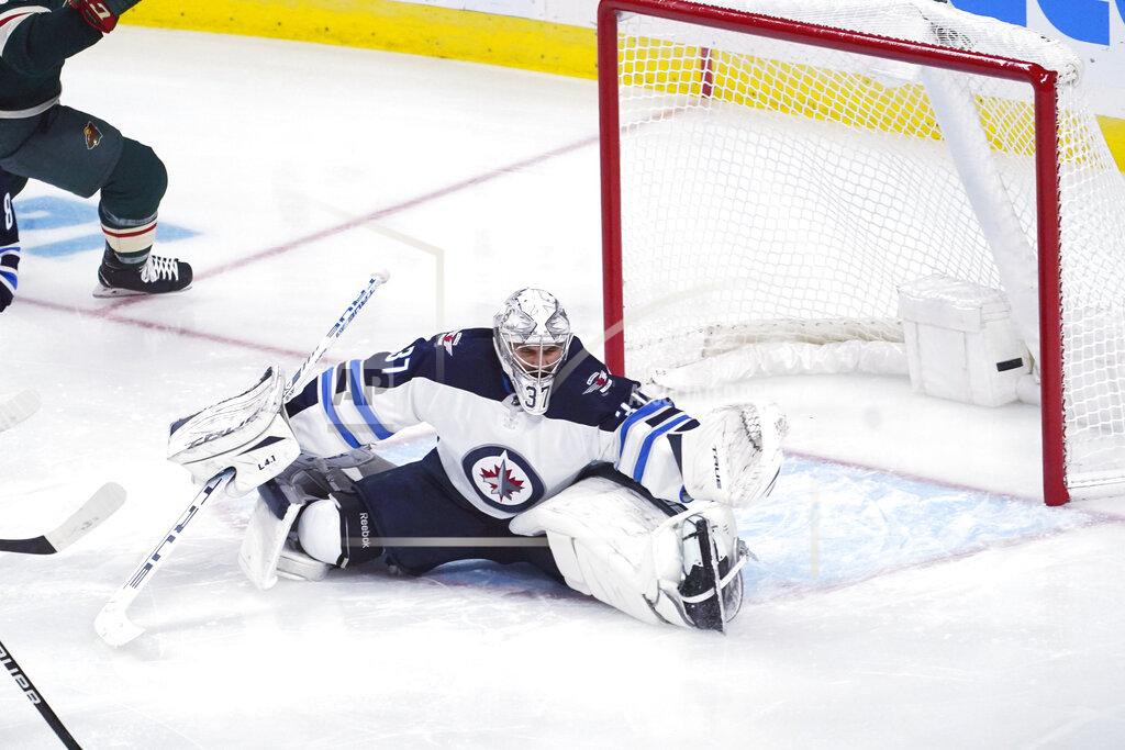 Jim Mone The puck shot by Minnesota Wild's Mats Zuccarello sails past Winnipeg Jets goalie Connor Hellebuyck for a goal during the first period of an NHL hockey game Tuesday, Oct. 19, 2021, in St. Paul, Minn. (AP Photo/Jim Mone)