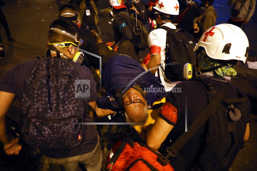 Rodrigo Abd Red Cross workers aid a protester who was injured during clashes with police launching tear gas to disperse protesters gathered in Plaza San Martin to demonstrate their refusal to recognize Peru's new government, in Lima, Saturday, Nov. 14, 2020. Peru’s Congress voted overwhelmingly to remove now ex-President Martín Vizcarra on Monday. (AP Photo/Rodrigo Abd)