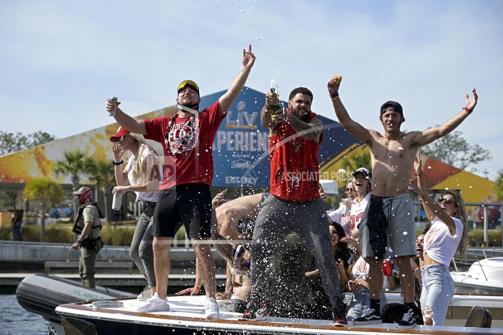 Phelan Ebenhack Tampa Bay Buccaneers NFL football tight end Tanner Hudson left, wide receiver Mike Evans, middle, and wide receiver Scott Miller celebrate their Super Bowl 55 victory over the Kansas City Chiefs with a boat parade in Tampa, Fla., Wednesday, Feb. 10, 2021. (AP Photo/Phelan Ebenhack)