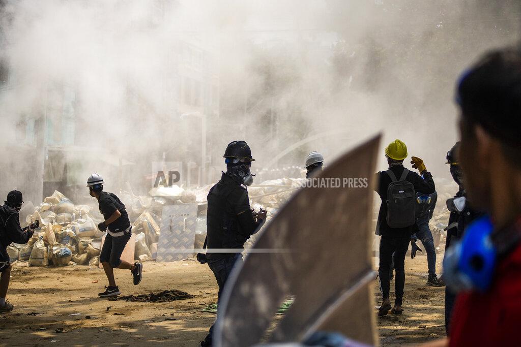 Uncredited FILE - In this March 14, 2021, file photo, anti-coup protesters scatter during an ongoing police crackdown during a protest in Sanchaung township, Yangon, Myanmar. Protests in Myanmar's largest city turned deadly in March as security forces continued their violent crackdown against dissent following the military coup. Former United Nations Secretary General Ban ki-Moon is urging the world body and Southeast Asian countries to take swift and "strong action" to stop the deadly crackdown in the wake of a military coup in Myanmar. (AP Photo/File)
