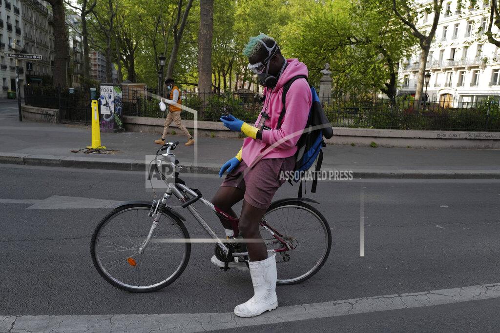 Francois Mori FILE - In this April 20, 2020 file photo, a delivery man, who want to name Moise, wearing protective gear checks his phones during a nationwide confinement in Paris. France is rolling out its contact-tracing app aimed to help containing the spread of the virus as life slowly returns to normal while most of its neighbors, including the UK, Germany, Italy are also about to launch their own technology. (AP Photo/Francois Mori, File)