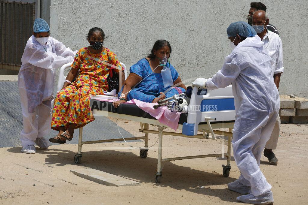 Ajit Solanki Health worker carry patients to shift them from a dedicated COVID hospital to another hospital to vacate the bed for new patients, at Civil hospital in Ahmedabad, India, Tuesday, April 13, 2021. New infections have surged in the past month and India has now reported over 13.6 million cases, pushing its toll past Brazil, and making it second only to the United States. In the past 24 hours, over 160,000 new infections have been detected and experts fear that the worst is yet to come. (AP Photo/Ajit Solanki)