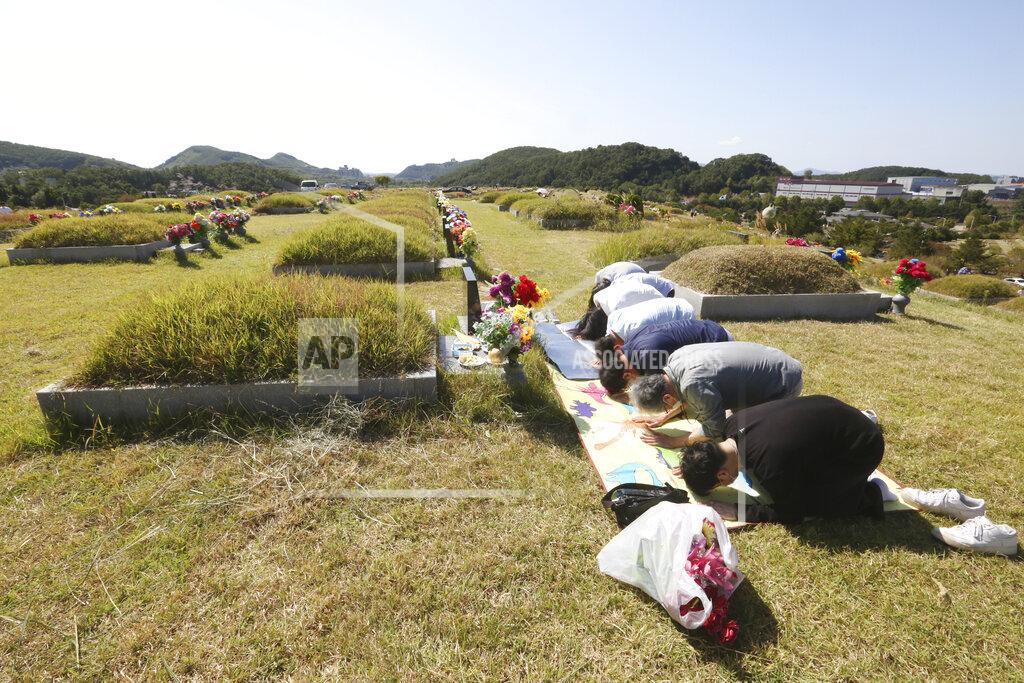 Ahn Young-Joon Family members bow to respect at their ancestral cemetery ahead of Chuseok holiday, the Korean version of Thanksgiving Day, at a cemetery in Paju, South Korea, Sunday, Sept. 27, 2020. South Korea's national cemeteries will be closed during the upcoming Chuseok holiday during the five-day holidays from Sept. 30 to Oct. 4 to prevent the spread of the coronavirus. (AP Photo/Ahn Young-joon)