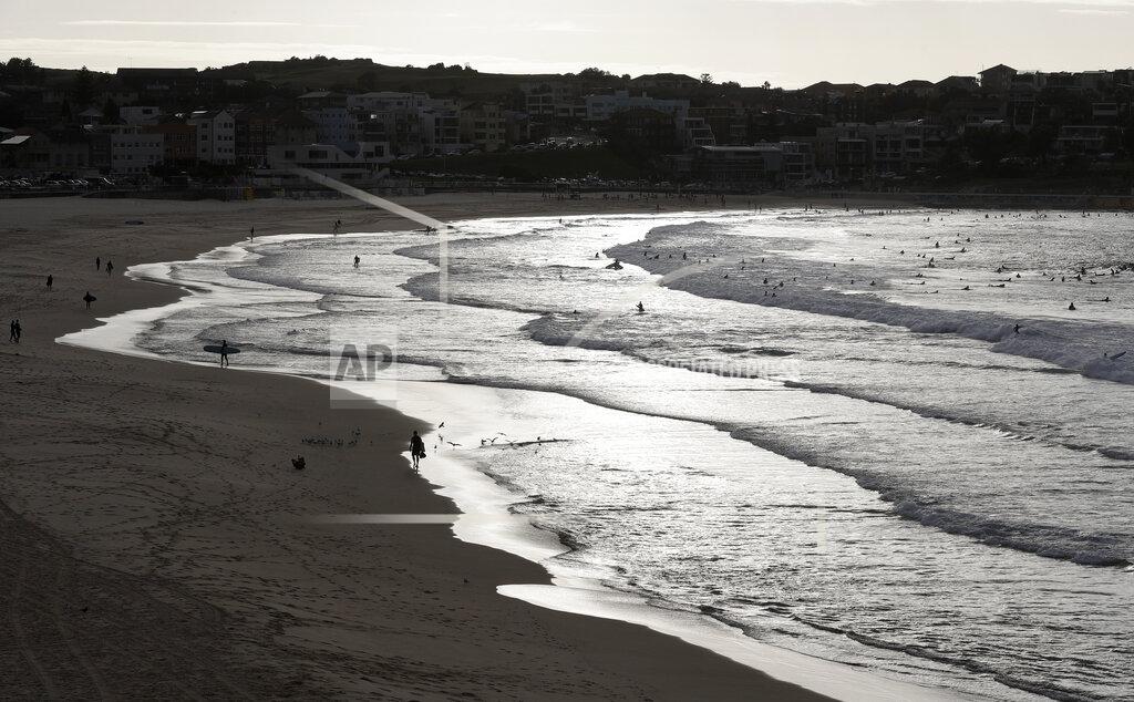 Rick Rycroft Surfers enjoy the water at Bondi Beach in Sydney, Tuesday, April 28, 2020, as coranavirus pandemic restrictions are eased. The beach is open to swimmers and surfers to exercise only. (AP Photo/Rick Rycroft)
