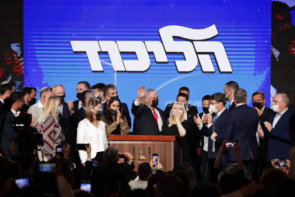 Maya Alleruzzo Israeli Prime Minister Benjamin Netanyahu, center, with his party members waves to his supporters after the first exit poll results for the Israeli parliamentary election at his Likud party's headquarters in Jerusalem, Wednesday, March. 24, 2021.(AP Photo/Maya Alleruzzo)