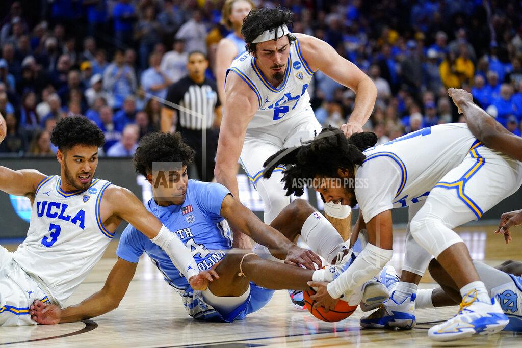 Matt Rourke UCLA's Johnny Juzang, from left, Jaime Jaquez Jr. and Tyger Campbell battle for a loose ball with North Carolina's Puff Johnson, second from left, during the second half of a college basketball game in the Sweet 16 round of the NCAA tournament, Friday, March 25, 2022, in Philadelphia. (AP Photo/Matt Rourke)