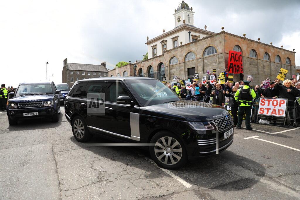 Peter Morrison Demonstrators protest as the motorcade of British Prime Minister Boris Johnson drives past on the way to Hillsborough Castle, in Hillsborough, Northern Ireland, Monday, May, 16, 2022. Johnson on Monday renewed British threats to break a Brexit agreement with the European Union, blaming it for a political crisis that's blocking the formation of a new government in Northern Ireland. (AP Photo/Peter Morrison)